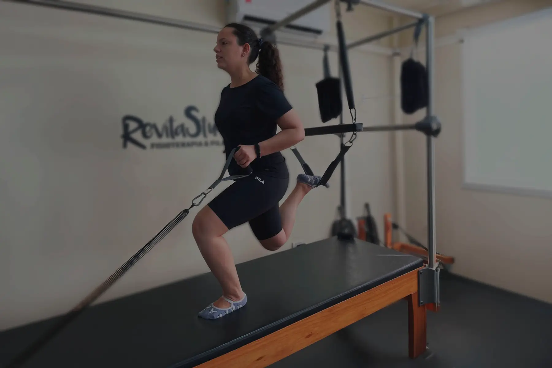Aluna em exercício de fortalecimento no aparelho Cadillac do Revita Studio, em São Gonçalo